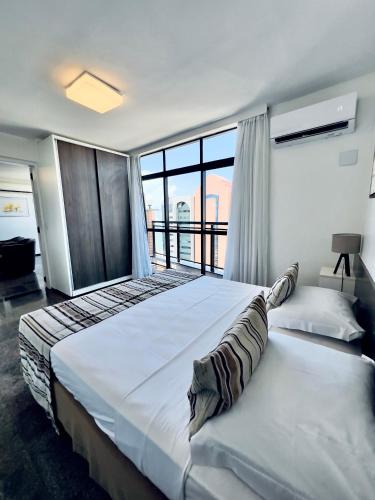 a bedroom with a large bed with a large window at Hotel Brasil Tropical in Fortaleza