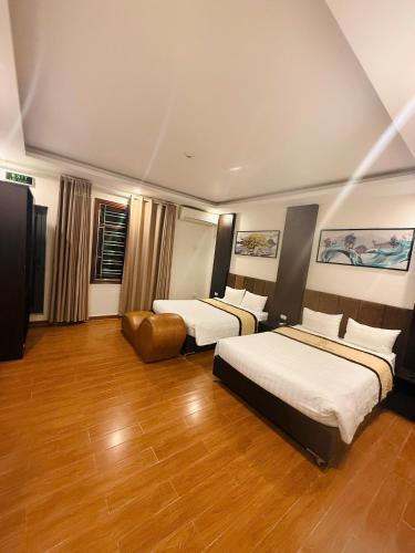 a hotel room with two beds and a chair at Phú Điền Motel in Ðại Sơn