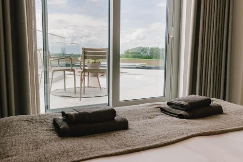 a bedroom with a bed with a view of a patio at De Droomtoren - uniek overnachten in een watertoren nabij Maastricht in Riemst