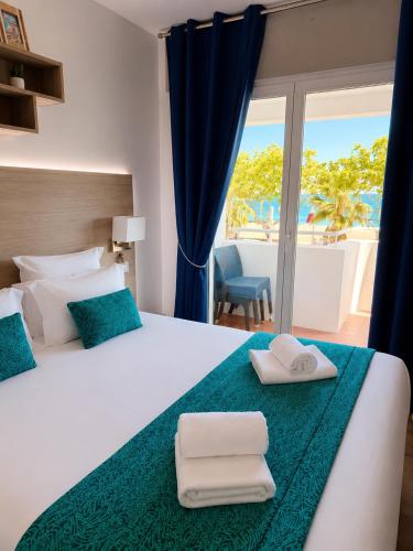 a bedroom with a bed with two towels on it at Les Palmiers in Fréjus