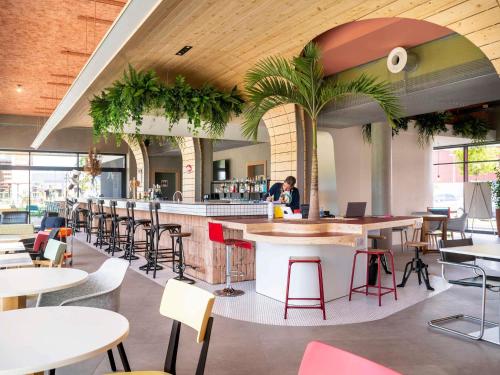 a restaurant with a bar with tables and chairs at greet hotel Cernay Mulhouse in Cernay