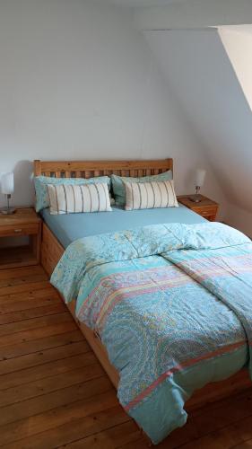 a bed with a wooden headboard in a bedroom at Eulen- & Altstadtnest in Peine