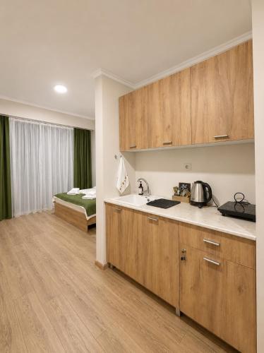 a kitchen with wooden cabinets and a bed in a room at N4 Alvina Complex in Tsaghkadzor