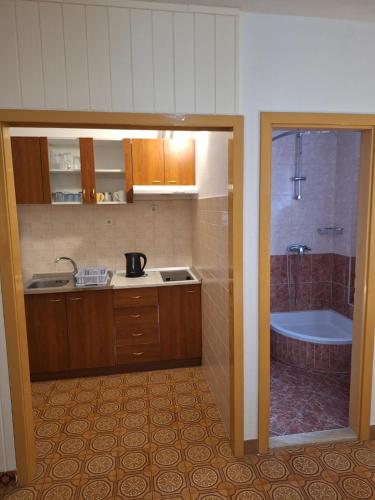 a kitchen with a tub and a sink and a bath room at Apartmani Emi in Tučepi