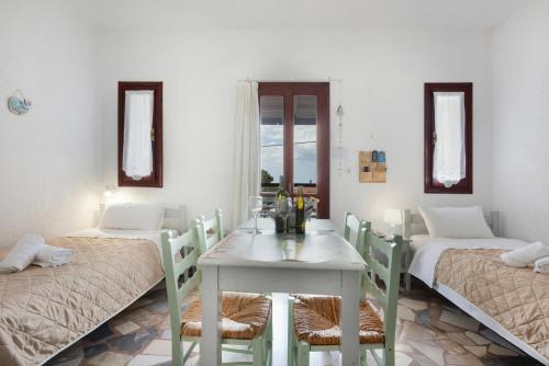 a room with two beds and a table with chairs at Apartment with sea view - Creta in Ferma