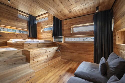 a cabin with three beds in a room with wooden walls at Design Lodge The Cube in Ortisei