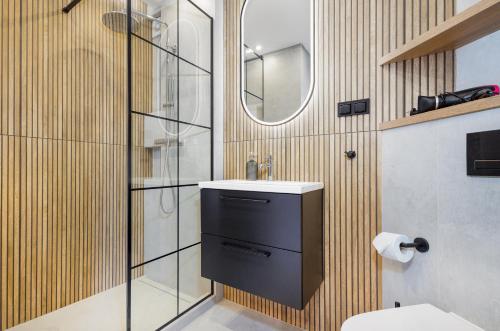 a bathroom with a sink and a mirror at BOOKS & SUN by the Sea Air-conditioned Apartment in Władysławowo