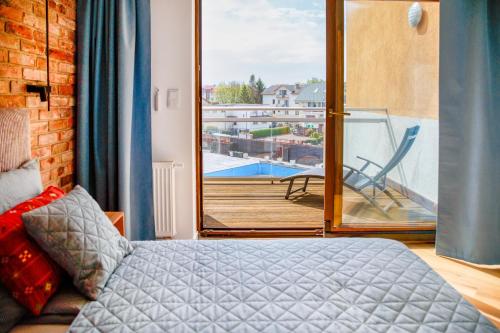 a bedroom with a bed and a balcony with a view at BOOKS & SUN by the Sea Air-conditioned Apartment in Władysławowo