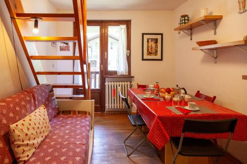 a dining room with a table with a red table cloth at Appartamento in stile alpino a Courmayeur in Verrand