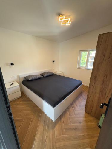 a bedroom with a bed and a wooden floor at Bellavista in Strožanac