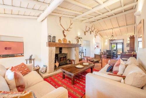 a living room with white furniture and a fireplace at Authentic Alentejo Farmhouse in Arraiolos