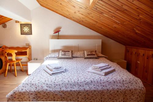 a bedroom with a bed with towels on it at Appartamento in stile alpino a Courmayeur in Verrand