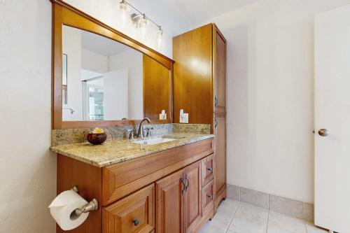 a bathroom with a sink and a large mirror at Flip Flops & Sand Beach house in Wells