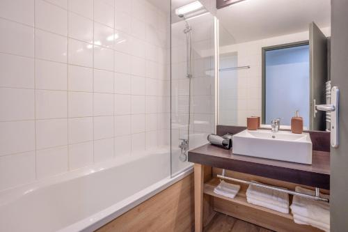 a bathroom with a sink and a bath tub at Les Charmes C10 - Le Val Joly in Eppe-Sauvage