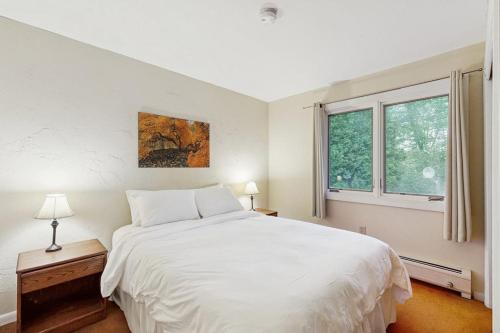 a white bedroom with a large bed and a window at Seasons 208 in Warren