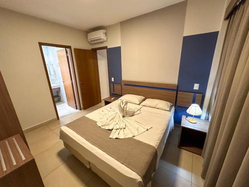 a hotel room with a bed with a robe on it at Alta Vista Thermas - OFICIAL in Caldas Novas