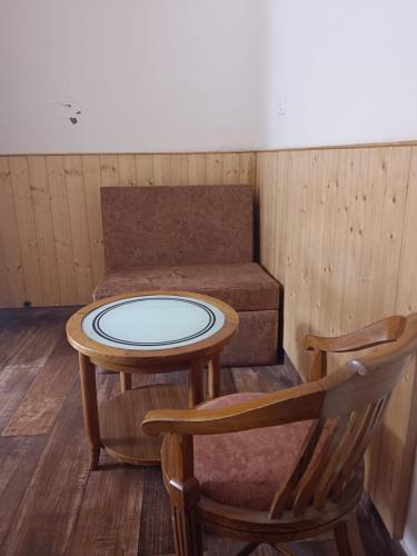 a small table and a chair in a room with a couch at The Kumaon Retreat in Nainital