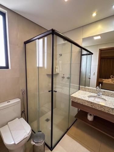 a bathroom with a shower and a toilet and a sink at Alta Vista Thermas - OFICIAL in Caldas Novas