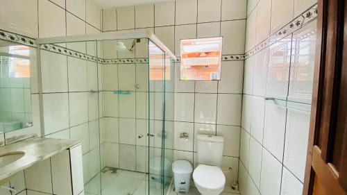 a bathroom with a toilet and a glass shower at Hostel Agatha in Paraty
