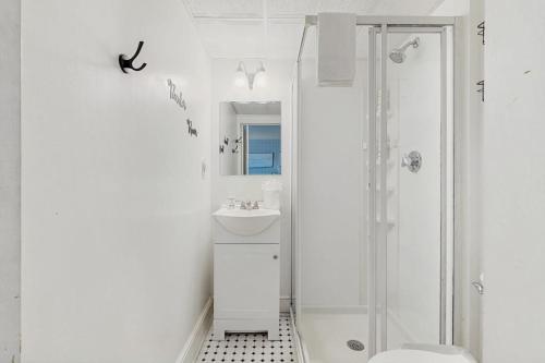 a white bathroom with a shower and a sink at Salty Breeze Studio in Wells