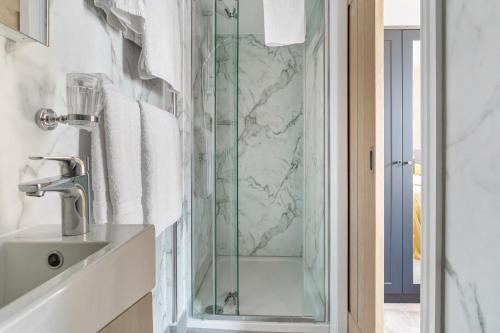 a glass shower in a bathroom with a sink at The Westgate in Torquay