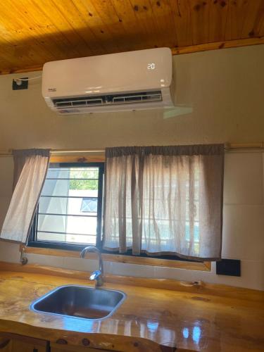 a kitchen with a sink and a window at Cabañas Los Robles Premium in Villa Quillinzo