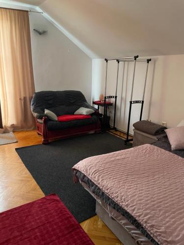 a living room with a bed and a couch at Apartman 1 in Krnjača
