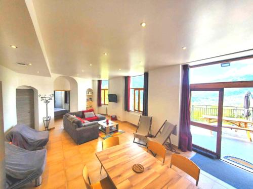a large living room with a table and a couch at Location Paradiski San Bernardo in Séez