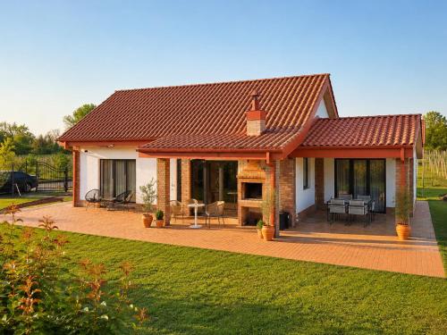 a small house with a red roof and a patio at Villa Lazarina Vineyard Views in Kvareli