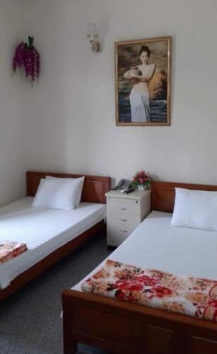 a room with two beds and a picture on the wall at Thùy Dung 62 in Ha Long