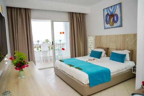 a bedroom with a large bed and a balcony at Caribbean World Mahdia in Mahdia