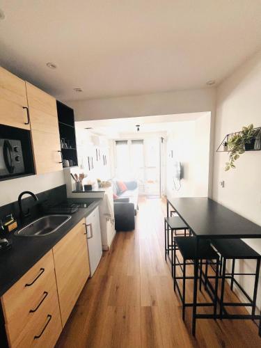 a kitchen with a sink and a table with chairs at Le studio terrasse Béthunois - Appart hôtel centre climatisé - All confort in Béthune