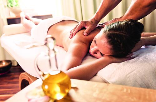 a man giving a woman a massage in a bed at Appartementhaus Absmeier in Bad Füssing