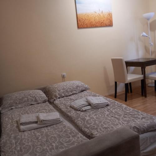 a bedroom with a bed with two towels on it at Apartman M 5 in Novi Sad