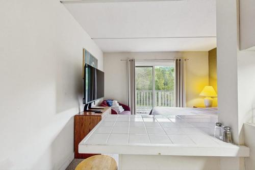 a white room with a bed and a television at Seasons 303 in Warren