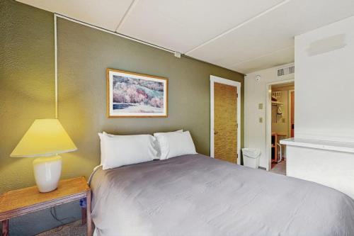 a bedroom with a bed and a lamp on a table at Seasons 303 in Warren