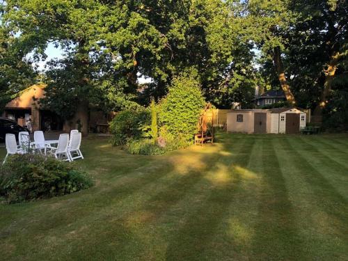 a yard with white chairs on the grass at Charming loft sleeps up to 9 with spa option in Bournemouth
