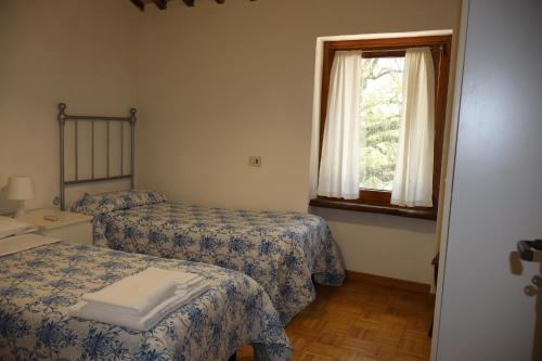 a bedroom with two beds and a window at Borgo Santa Cristina in Castel Giorgio