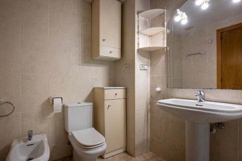 a bathroom with a toilet and a sink and a mirror at AT098 Pau Casals in Torredembarra