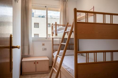 a bedroom with two bunk beds and a window at AT098 Pau Casals in Torredembarra