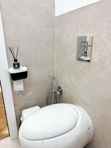 a bathroom with a white toilet in a room at DailyRentKZ in Kostanay