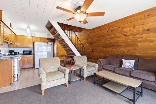 a living room with a couch and chairs and a kitchen at Chalet #25 in Stevensville