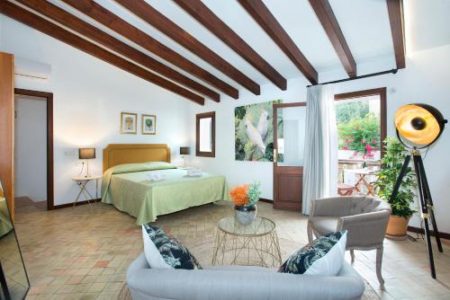 a bedroom with a bed and a couch in a room at Petit Caimari - Turismo de interior in Caimari