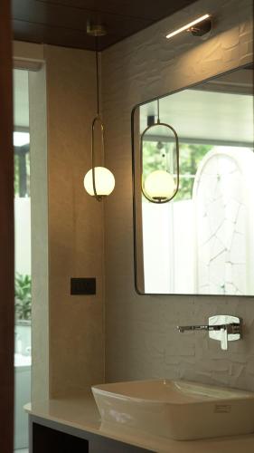 a bathroom with two lights hanging over a sink at La Damai in Aldūr