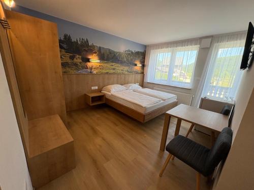 a bedroom with a bed and a table and a desk at Guesthouse Ema in Bohinj