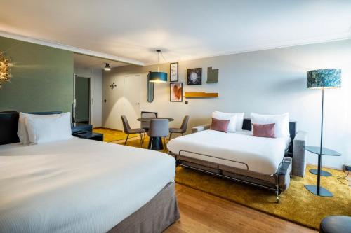 a hotel room with two beds and a table at Holiday Inn Hotel Brussels Airport by IHG in Diegem
