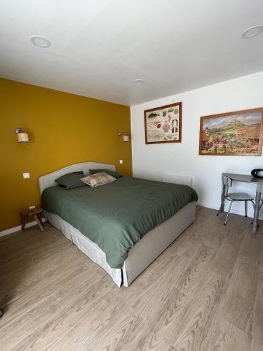 a bedroom with a bed and a table in it at La MaiZon in Lazenay