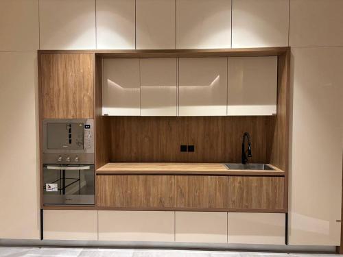 a kitchen with a sink and a microwave at شاليه بالم ون و فيلورا الفندقي in Buraydah