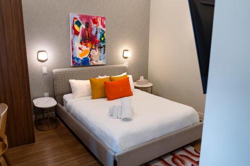 a bedroom with a bed with orange and yellow pillows at Arcadia Hotel Boutique in Montreal