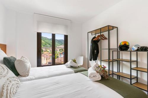 a bedroom with two beds and a window at Trail House in Pola de Lena